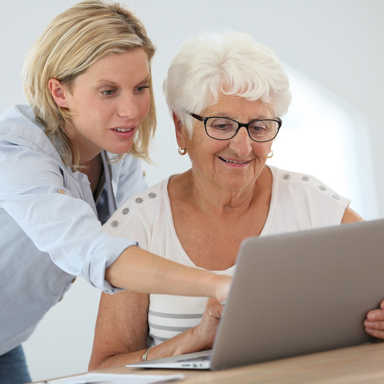 Home health aide assisting woman communicating online