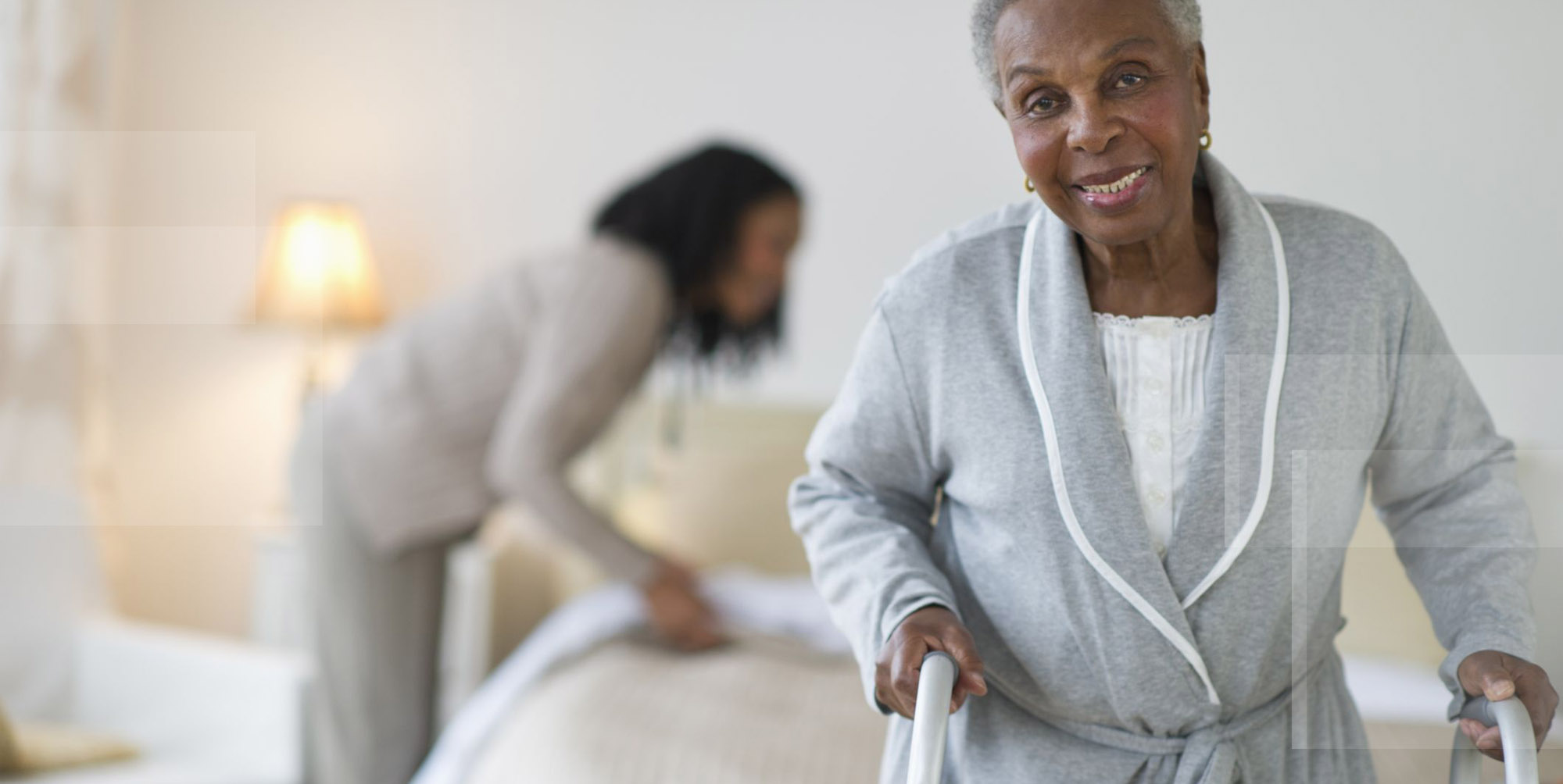 Assistant helping with ambulating and mobizing an elderly woman